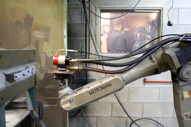 Plasma spray gun attached to a robot arm.