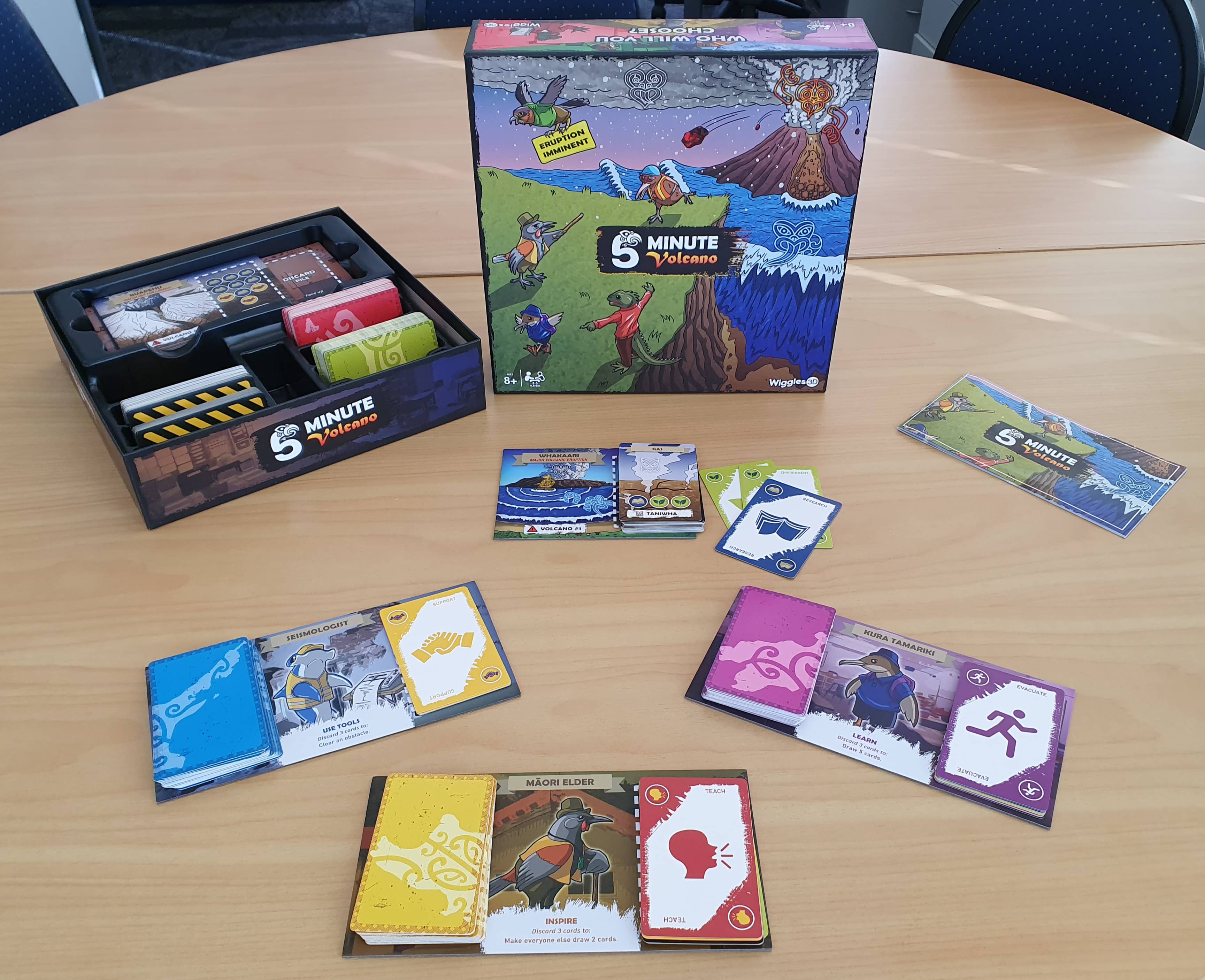 The 5-Minute Volcano board game box with cards and components.